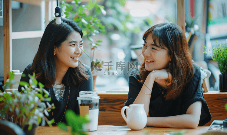 亚洲人年轻闺蜜在咖啡馆聊天