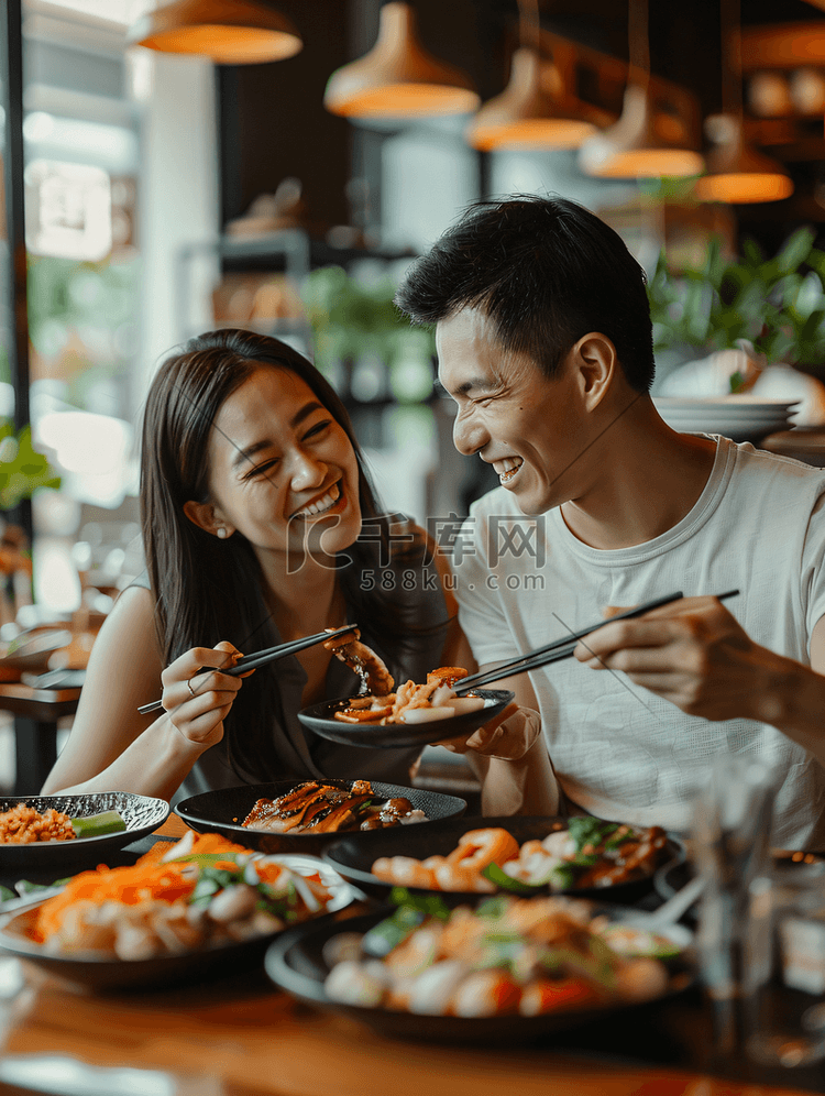 亚洲人快乐情侣在餐厅里用餐