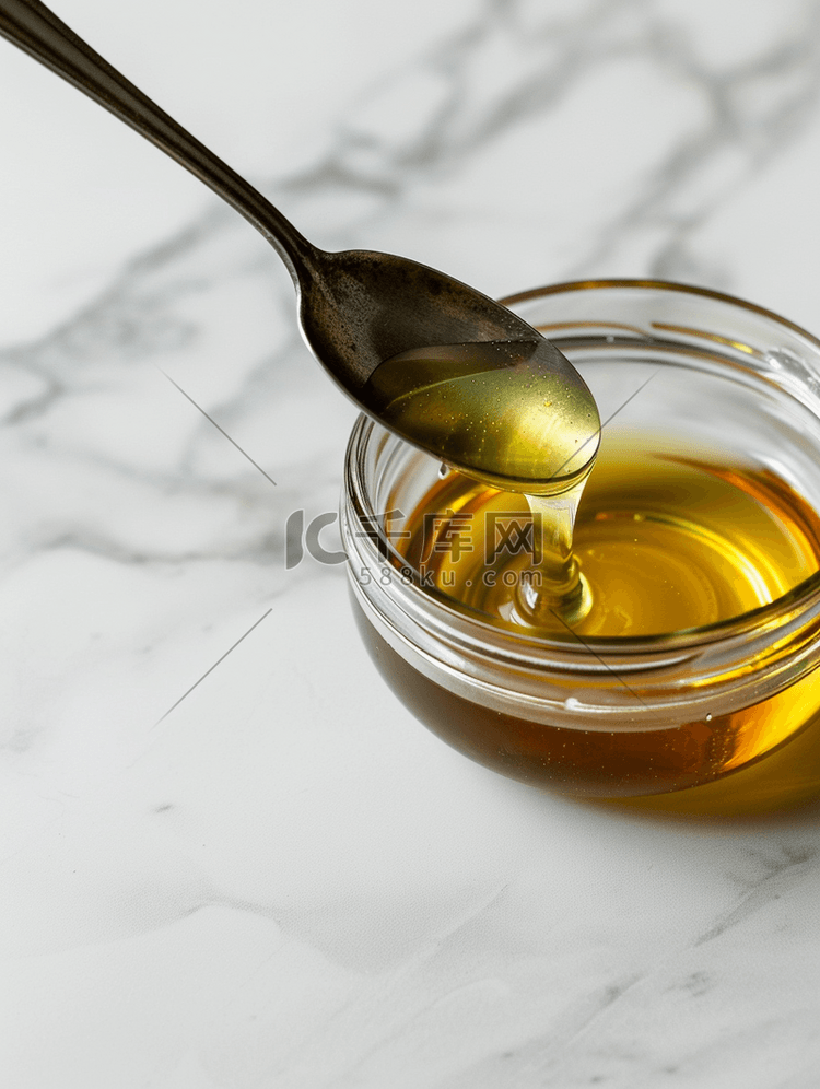 白蜂蜜从玻璃罐中的钢勺中流出