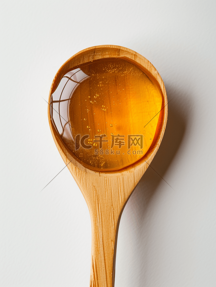 木勺中的蜂蜜具有白色背景中突显