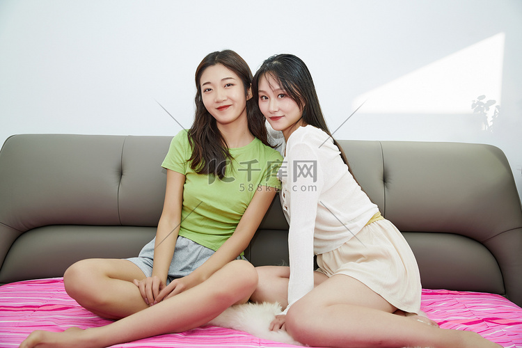 坐在床上玩耍的年轻亚洲美女闺蜜