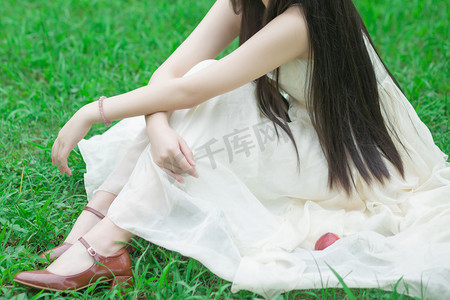 坐在草地摄影照片_坐在草地的长发女孩