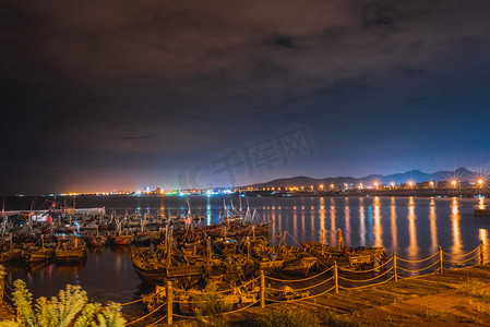 海边夜晚摄影照片_日照海边渔船夜景摄影图