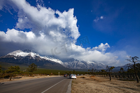 高山公路摄影照片_高山雪峰蓝天白云公路自然风景摄影图