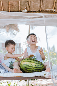 七月你好摄影照片_夏天瓜棚里的两个小孩子玩耍