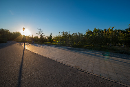 蓝天清晨暖阳公园影子被拉长摄影图