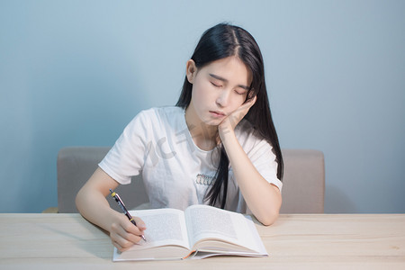 女学生摄影照片_室内看书学习的女学生打瞌睡