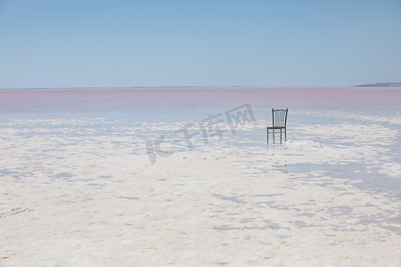 粉色盐湖上一把椅子摄影图