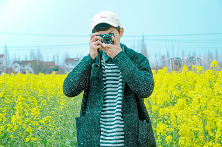 少年搏击摄影照片_田间油菜花摄影师摄影图