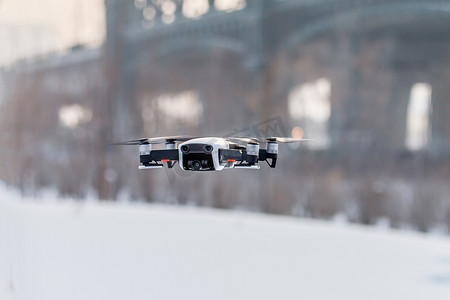 雪地里飞翔无人机摄影图