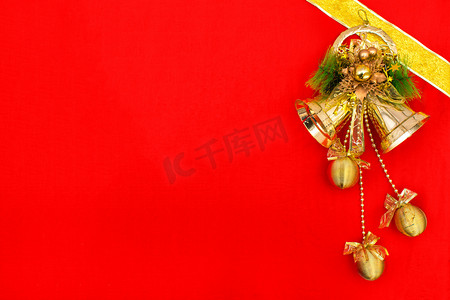 灵敏圆球摄影照片_红色背景上的金色圣诞铃铛摄影图