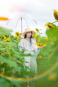 海里的萤火虫摄影照片_向日葵花海里漫步的少女