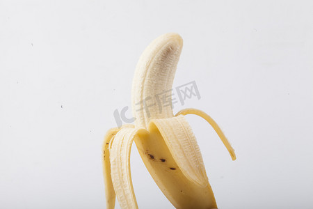 剥香蕉摄影照片_新鲜水果剥皮香蕉摄影图配图