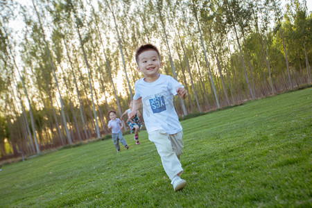 小孩摄影照片_草地上奔跑的小男孩