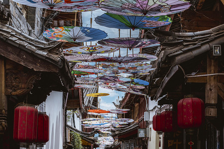 古城墙雪景摄影照片_丽江古城里的油纸伞摄影图