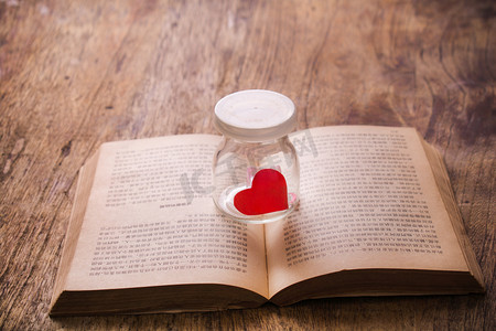 邂逅的浪漫摄影照片_木桌上的一颗红心书本文艺配图摄影图