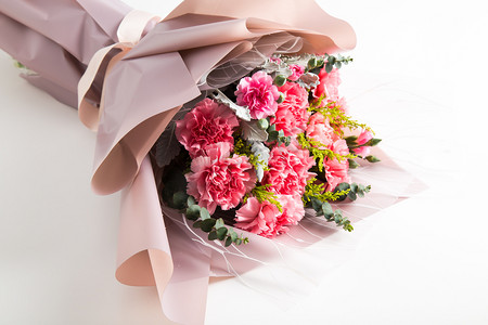 粉色刺绣旗袍摄影照片_康乃馨鲜花花束摄影图