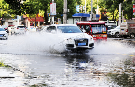 水花溅起的瓜果盘摄影照片_洪涝洪水下的城市飞驰的汽车水花摄影图