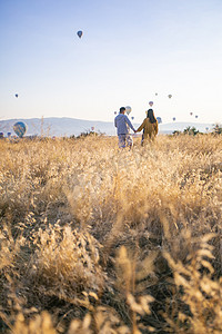 土耳其热气球摄影照片_情侣热气球麦田摄影图
