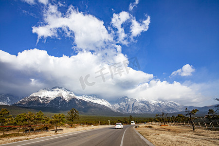 晴空摄影照片_高山雪峰蓝天白云公路自然风景摄影图