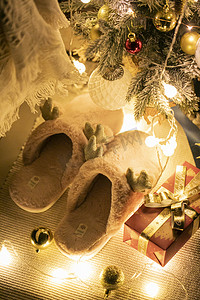 圣诞节圣诞树彩灯摄影照片_圣诞树下毛绒拖鞋摄影图