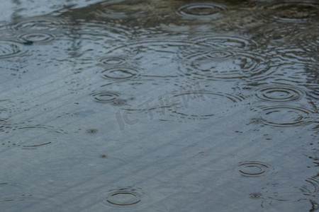 雨水落入水中泛起涟漪摄影图