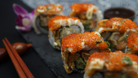 日式樱花底纹摄影照片_日式料理寿司卷鱼子酱三文鱼摄影图