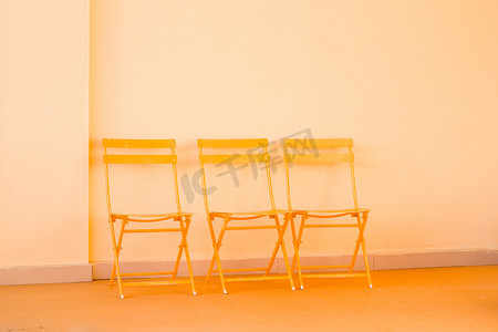简约橙色摄影照片_三把铁椅子摄影图