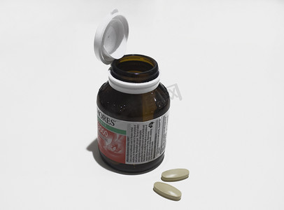 棕色玻璃药瓶和散落的药丸摄影图