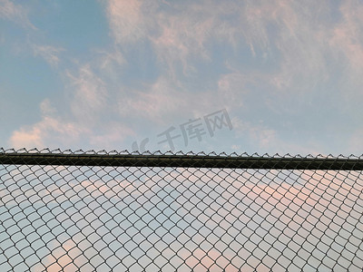 操场摄影照片_操场铁网围栏和天空背景摄影图