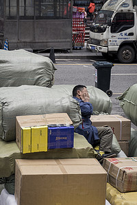 搬运货物摄影照片_劳动后在货物中休息的人
