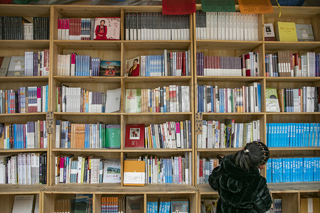 书店读书的人摄影照片_书店的书架