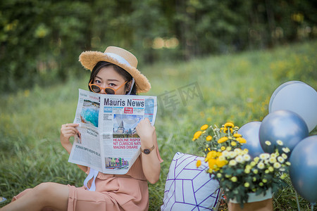 报纸美女摄影照片_夏天户外野餐 看报纸的女孩