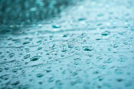 百合花雨珠摄影照片_汽车玻璃上雨水摄影图