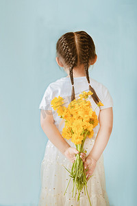 儿童节摄影照片_手拿金鸡菊的小女孩背影