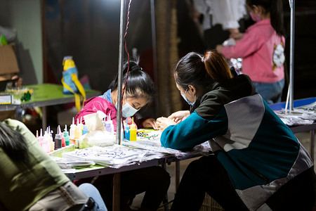 地摊摄影照片_夜市摊位画画家长摄影图