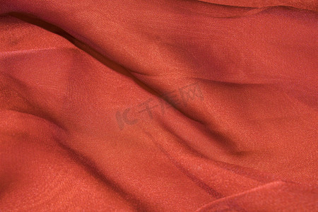 扁平化小插画摄影照片_橙红色丝绸布料摄影图配图
