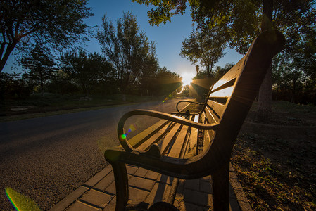 长椅摄影照片_清晨金色阳光洒在长椅上摄影图