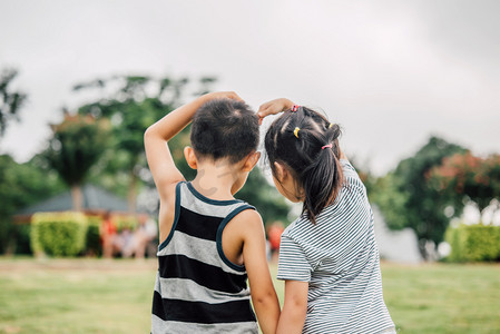 大人和小孩卡通摄影照片_比心小孩背影