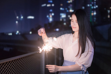 烟花仙女棒摄影照片_手持仙女棒的妹子