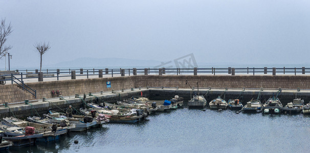 停靠码头摄影照片_停靠在港口岸边的渔船摄影图