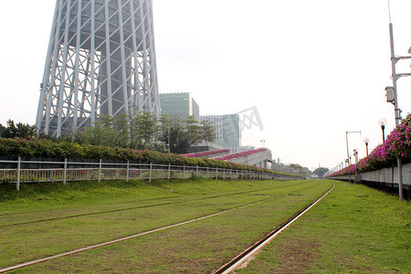 广州塔脚下草地红花铁轨摄影图