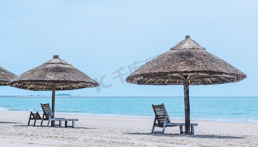 海南夏天摄影照片_海边旅游沙滩遮阳设备摄影图