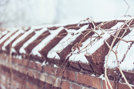 白雪覆盖砖瓦红墙摄影图