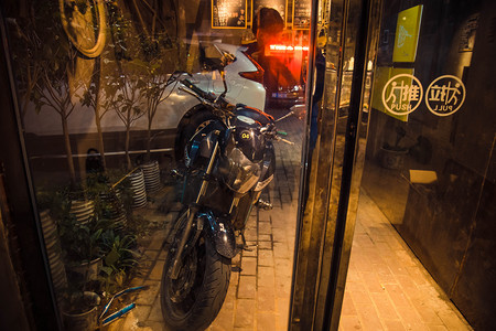 夜晚深夜摩托车玻璃门外近景交通生活方式摄影图