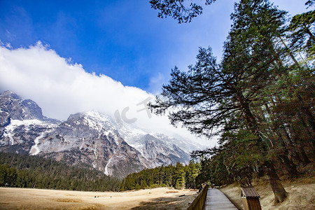 高山雪峰蓝天树木白云自然风景摄影图