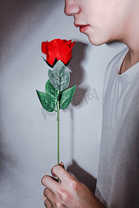 玫瑰摄影照片_拿着玫瑰花的人特写