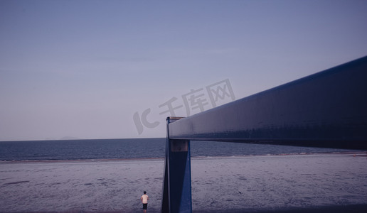 深蓝色蓝色摄影照片_自然风景阴天深蓝色海边沙滩摄影图配图