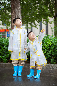 骑海豚的小孩摄影照片_雨后弟弟指向天空让哥哥看