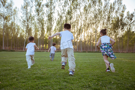 六一儿童节标题框摄影照片_草地上奔跑的孩子们的背影